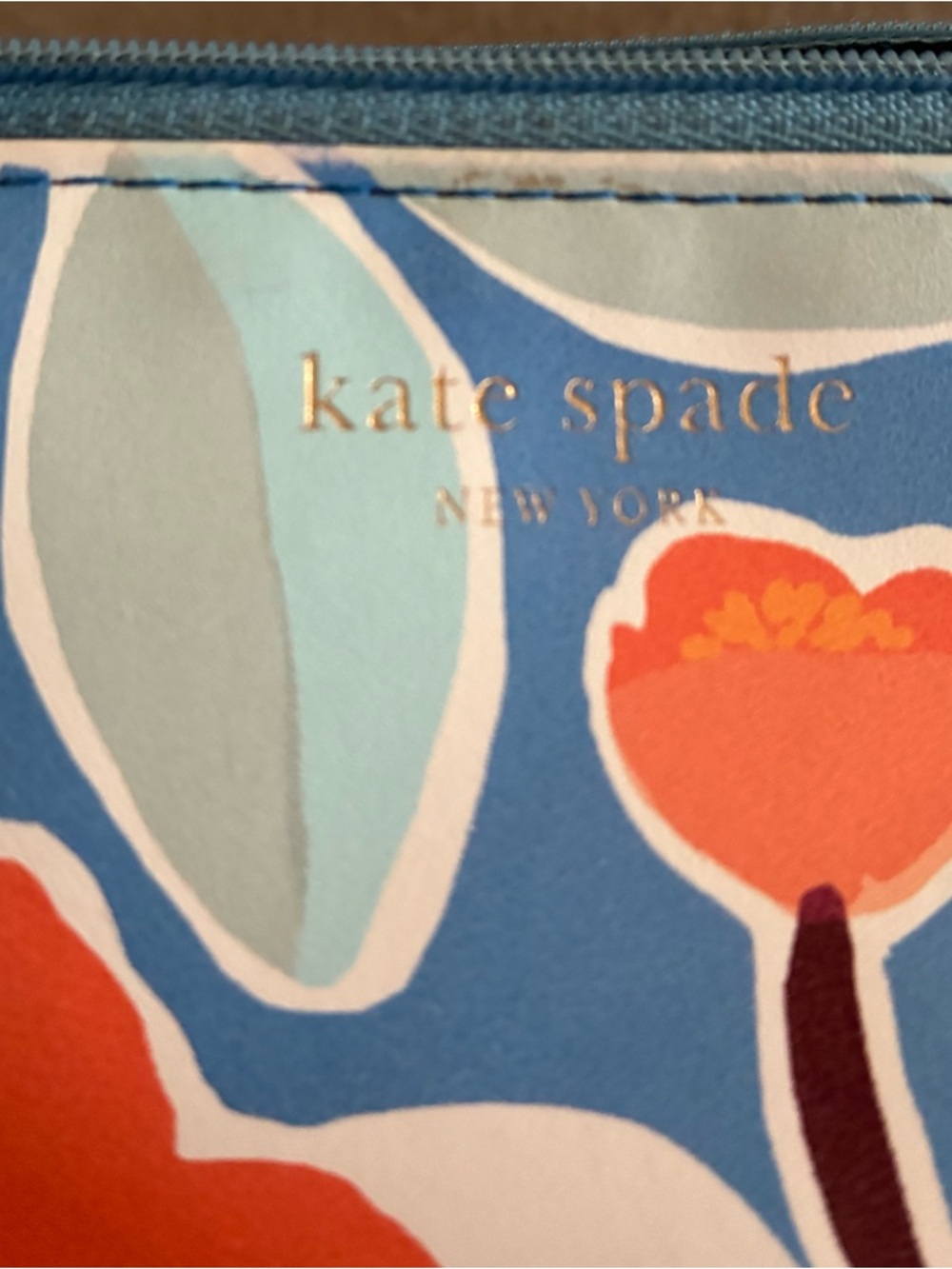 kate spade floral slim cosmetic bag in blue with orange accents